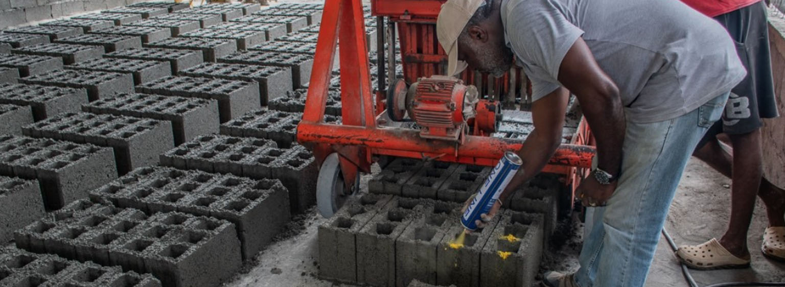 man leaning over cement blocks made from volcanic ash